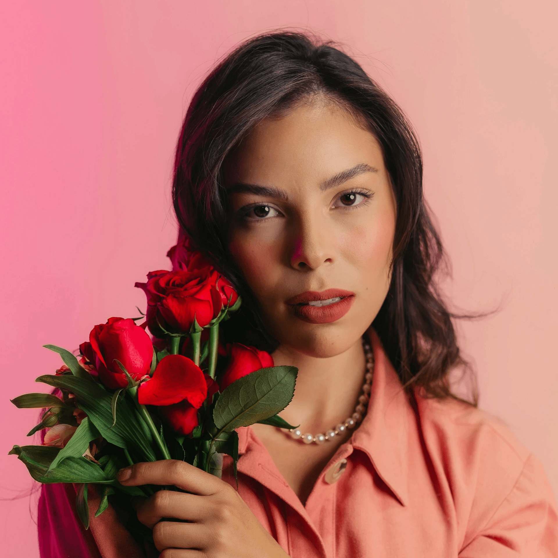 Woman holding flower on a pink background